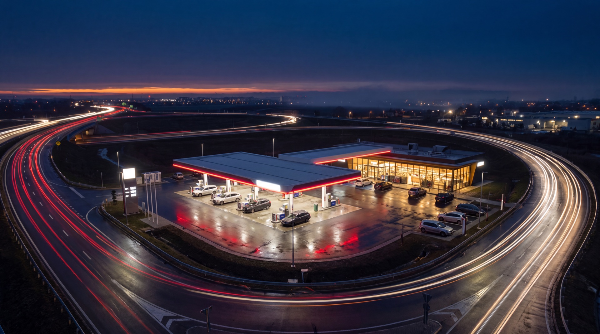 Aerial night view of a fuel station at a major highway interchange